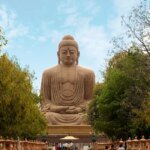 Tourists walking near the great Buddha statue in Bodh Gaya, India.