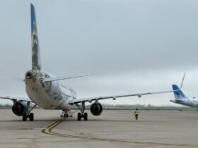 Frontier Airlines plane on the tarmac with another Frontier tail wing nearby