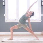 Woman in Reverse Warrior facing the long side of a mat and reaching her right arm alongside her head