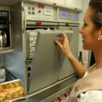 Flight Attendant using the oven onboard